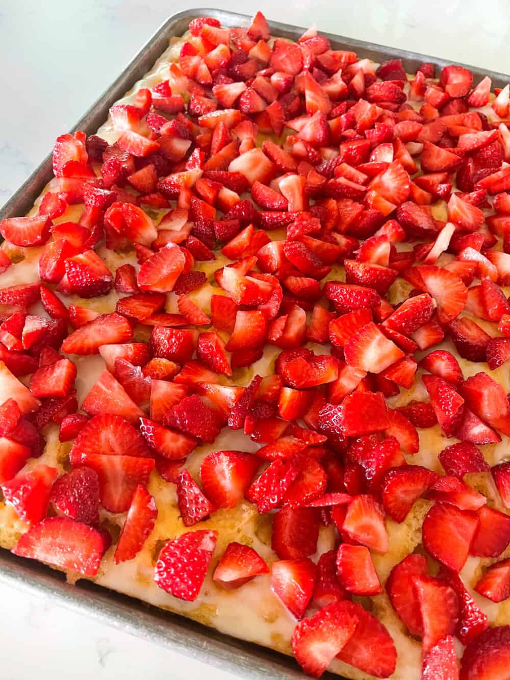 chopped strawberries over sheet cake
