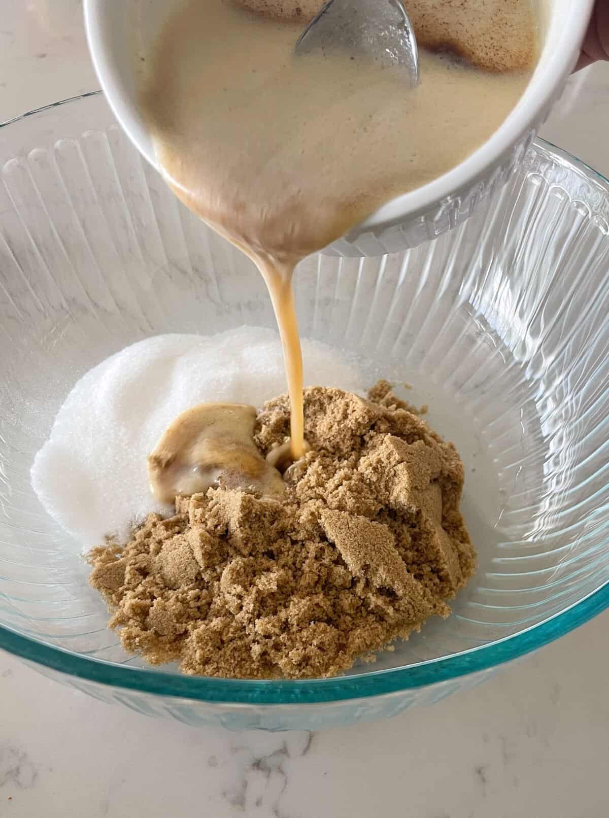 pouring brown butter into sugars in mixing bowl