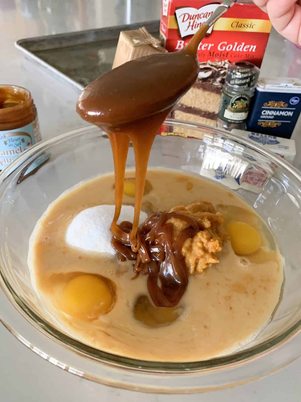 pouring caramel in mixing bowl for pumpkin bars