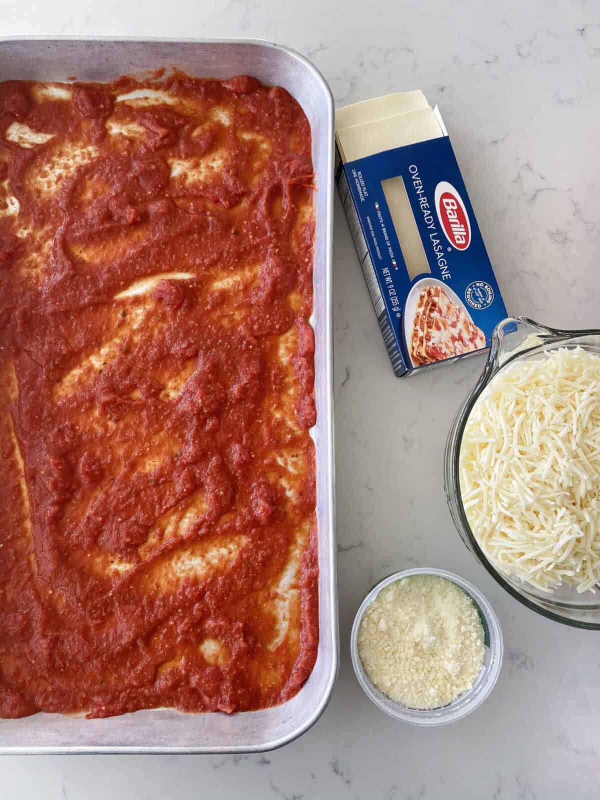 pasta sauce in bottom of lasagna pan