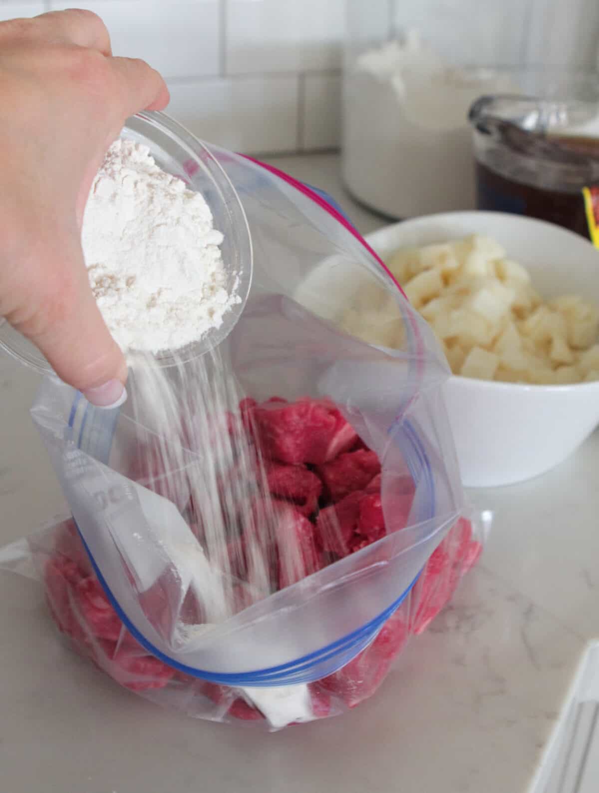 adding flour to stew meat in ziplock bag