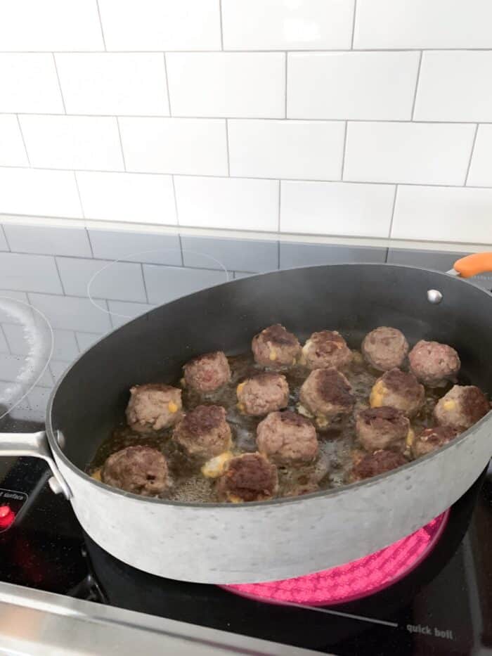 browned meatballs in hot pan