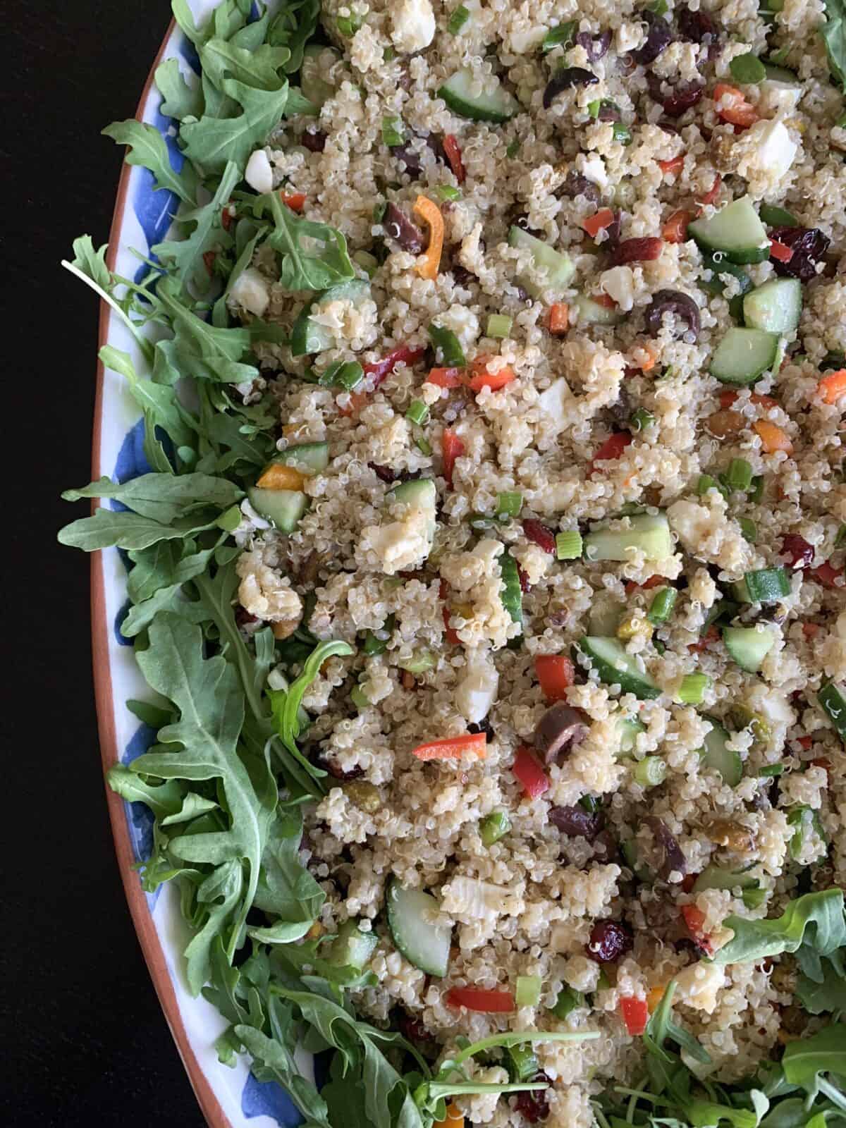 quinoa salad in large serving bowl over arugula