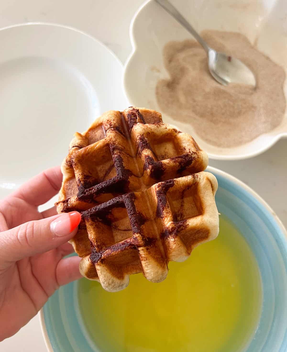 cooked waffle ready to be dipped in butter