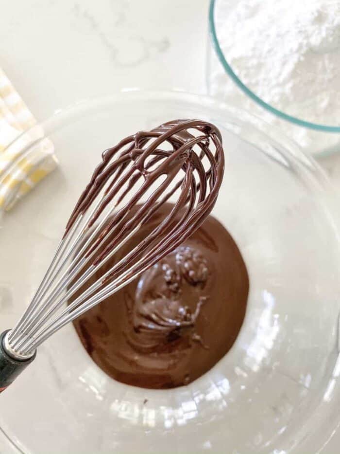 melted chocolate in mixing bowl with whisk