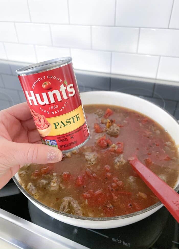 adding tomato paste to lasagna soup
