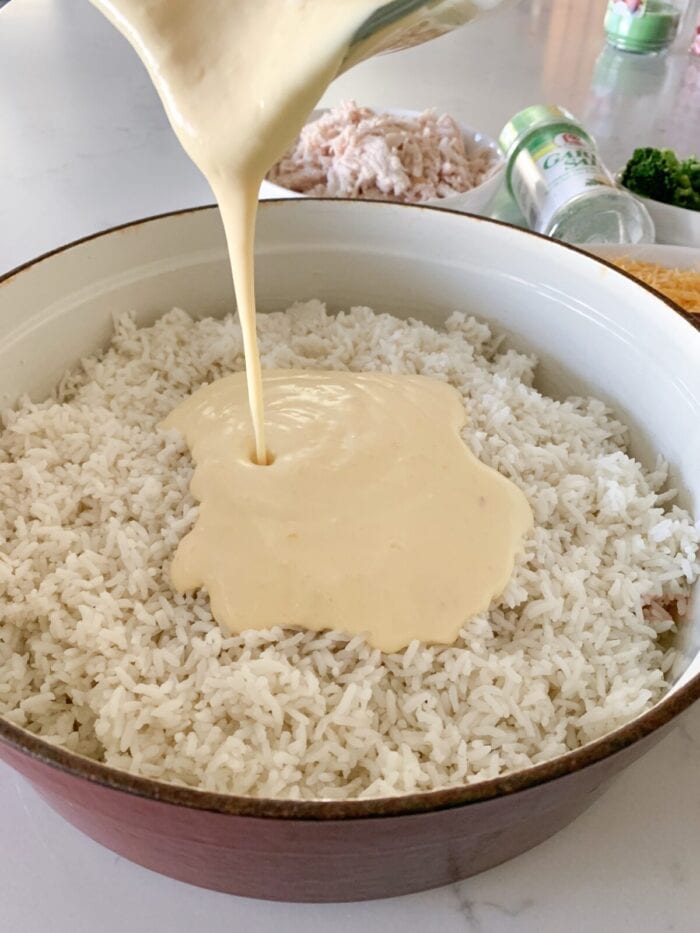 pouring soup mixture over cooked rice