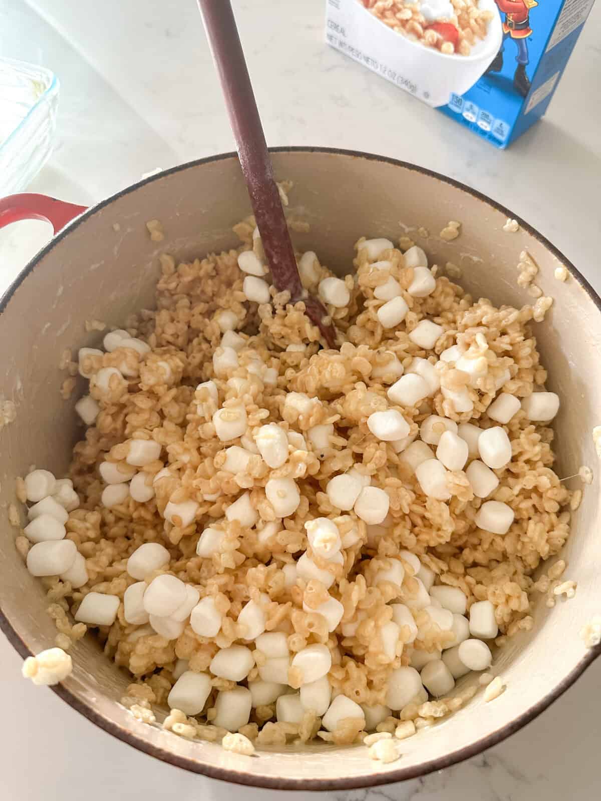 adding extra marshmallows to rice krispie treats in pot