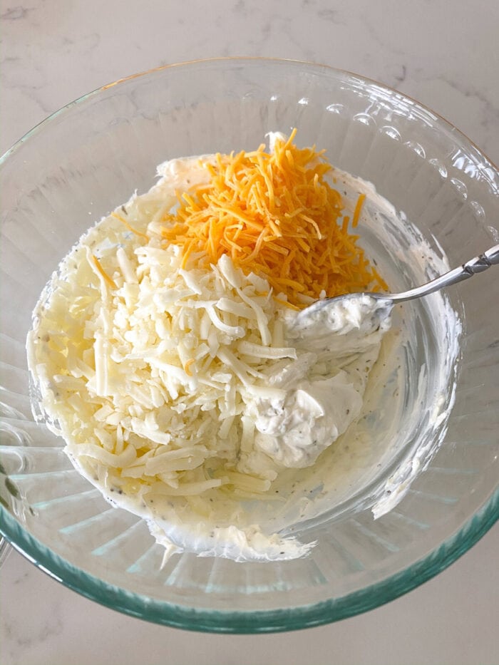 cheeses added to mixing bowl of cream cheese