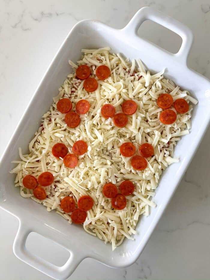 cheese and pepperoni in baking dish for pizza dip