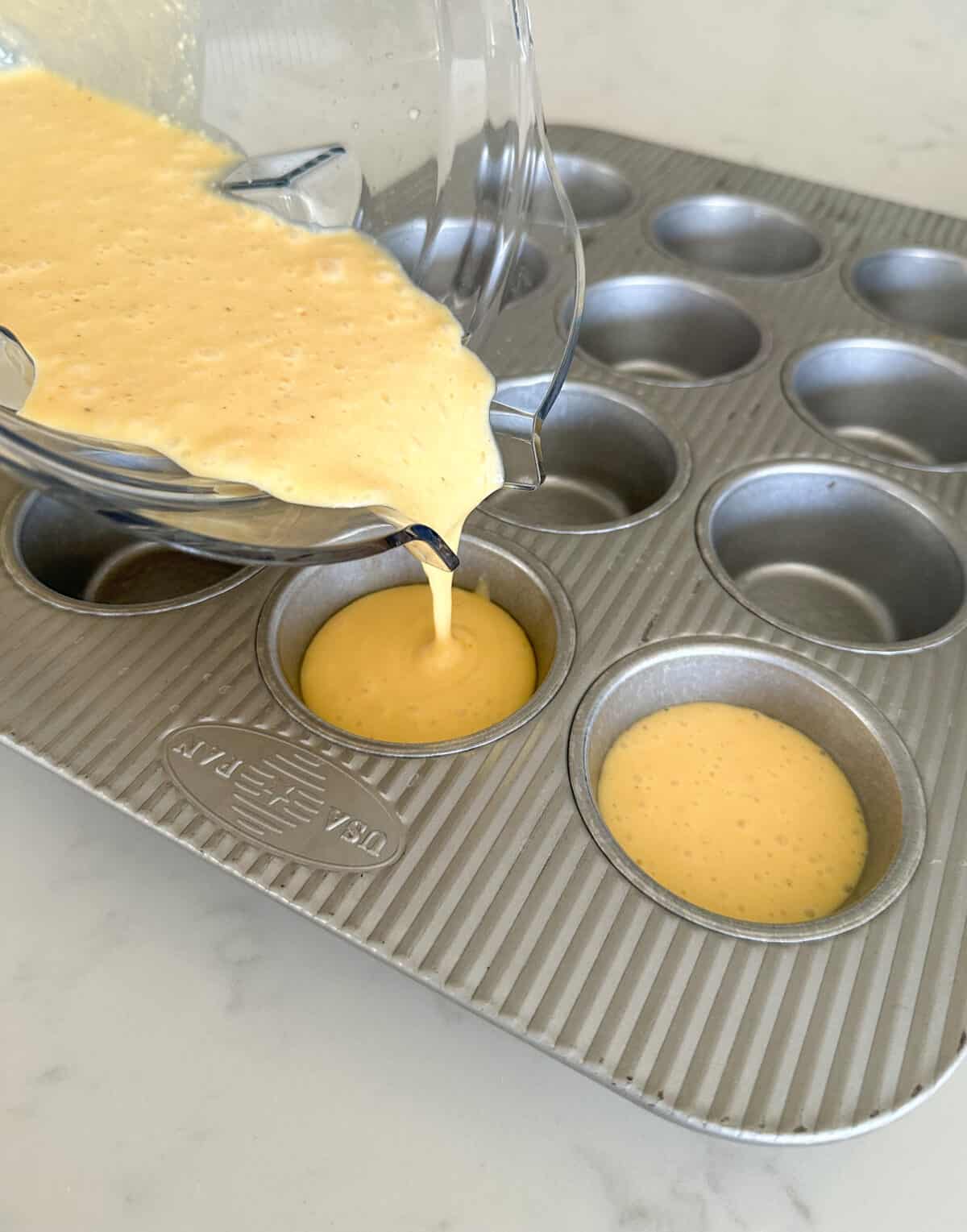 pouring egg mixture in muffin tin for egg bites