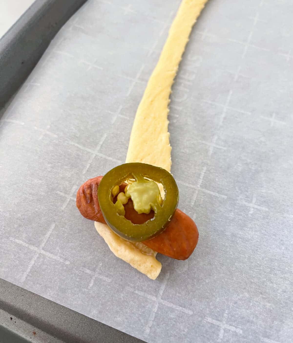 lil smokies and jalapeno placed on top of crescent roll.