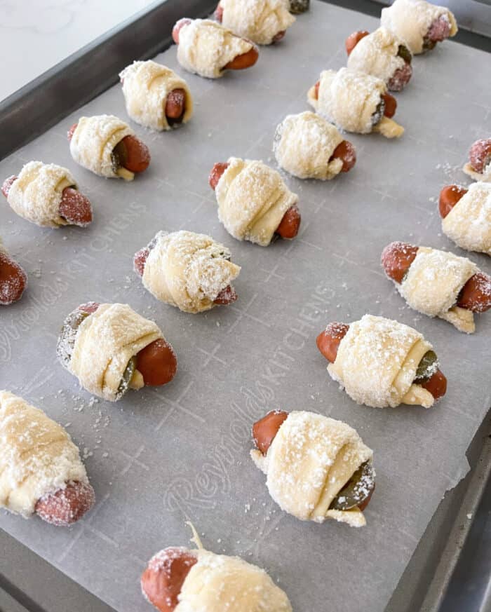 rolling pigs in a blanket in parmesan cheese