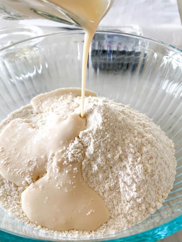 adding buttermilk to scone batter in mixing bowl