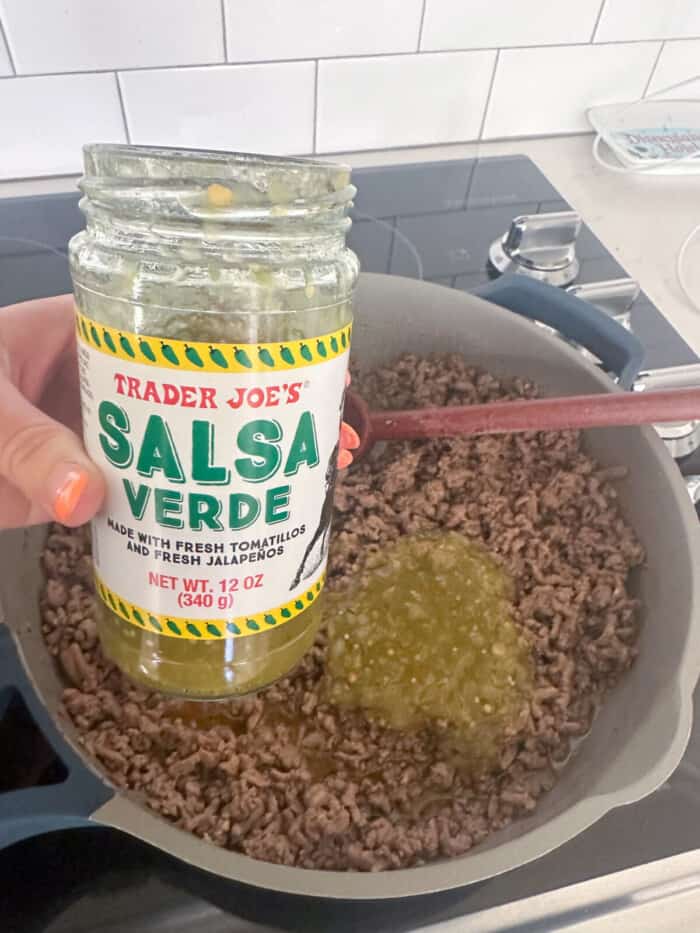 adding salsa verde to beef taco filling