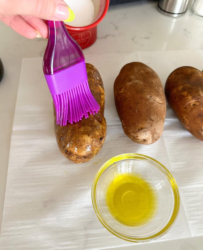 brushing potatoes with extra virgin olive oil