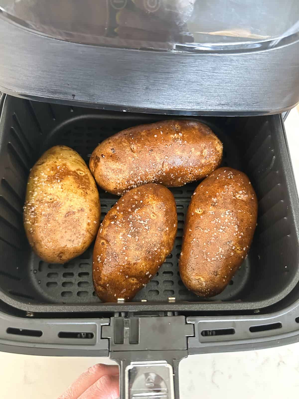 salted potatoes inside air fryer ready to cook