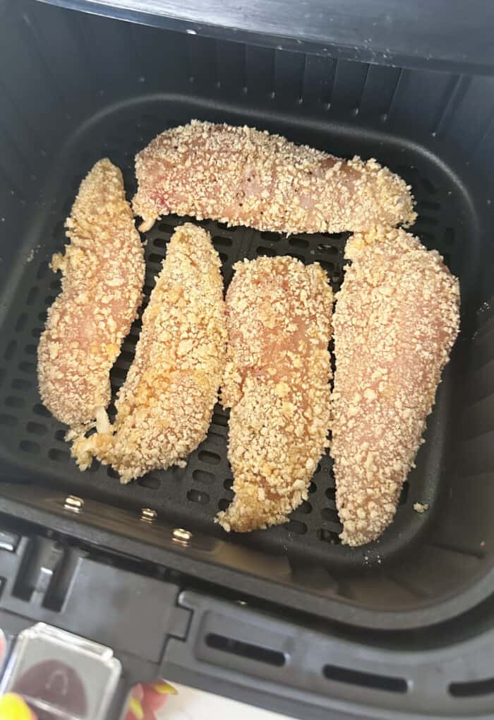 chicken tenders ready to cook inside air fryer basket