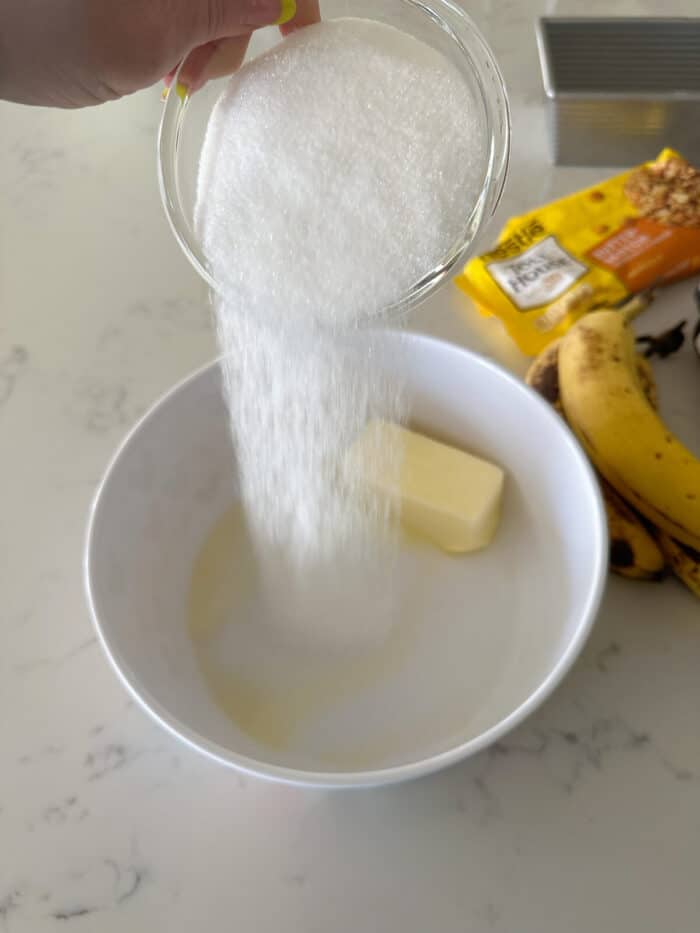 adding sugar to mixing bowl with butter