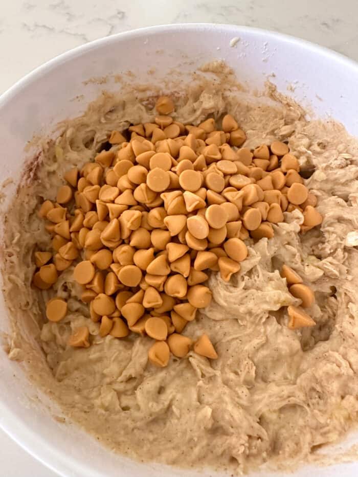 butterscotch chips added to banana bread batter in mixing bowl