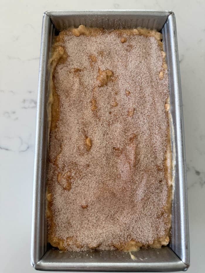 banana bread batter in loaf pan with cinnamon sugar topping