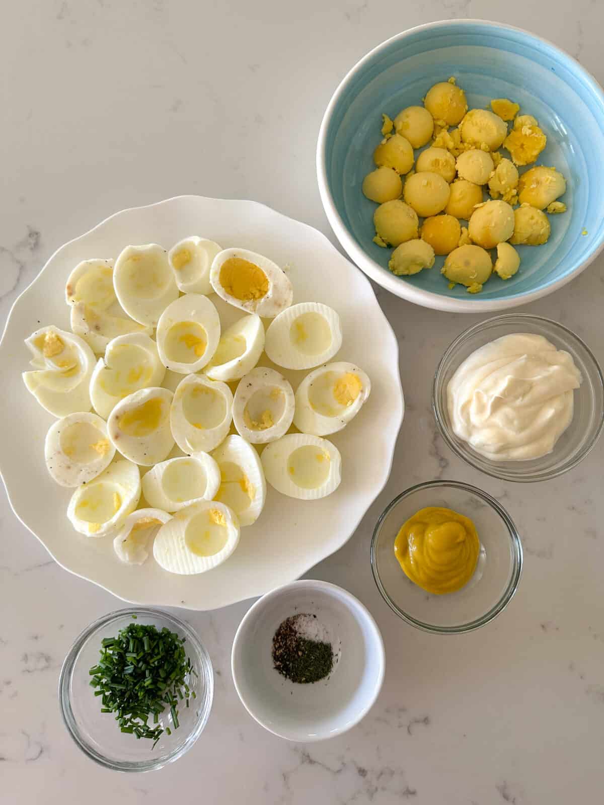 egg salad ingredients in bowls on counter