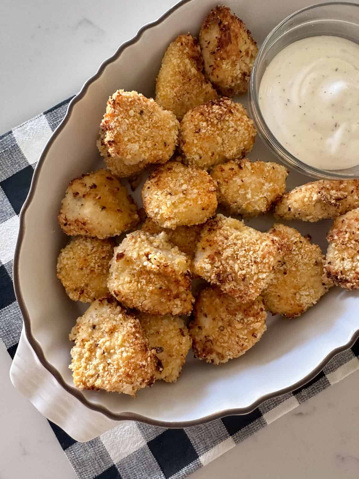 chicken nuggets in serving dish with dipping sauce.