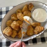 chicken nugget dipped in ranch dressing with a fork