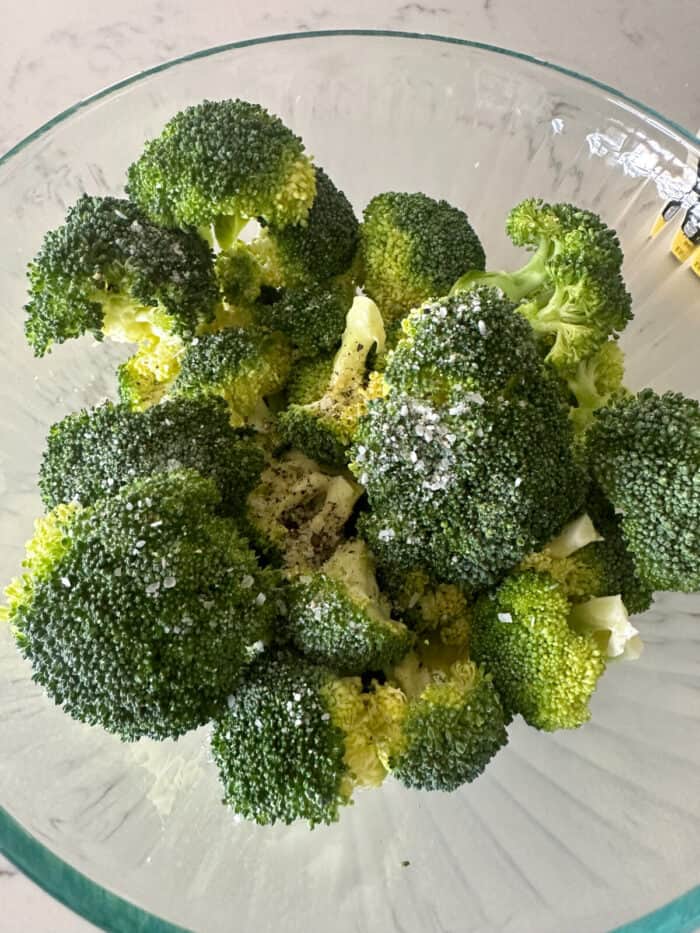 broccoli florets in large mixing bowl with seasonings