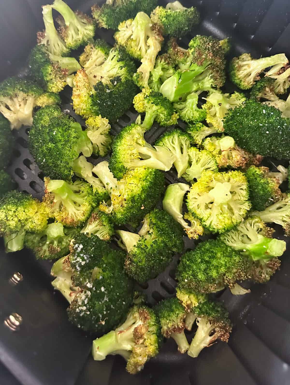 cooked broccoli in basket of air fryer