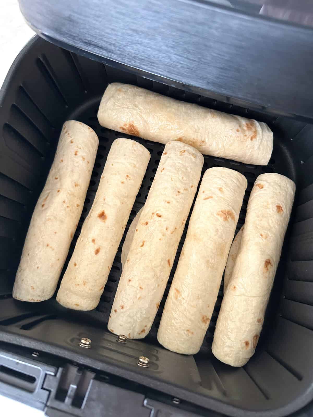 uncooked taquitos in air fryer basket