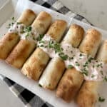 cooked chicken taquitos on serving plate