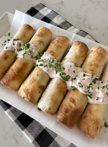 cooked chicken taquitos on serving plate