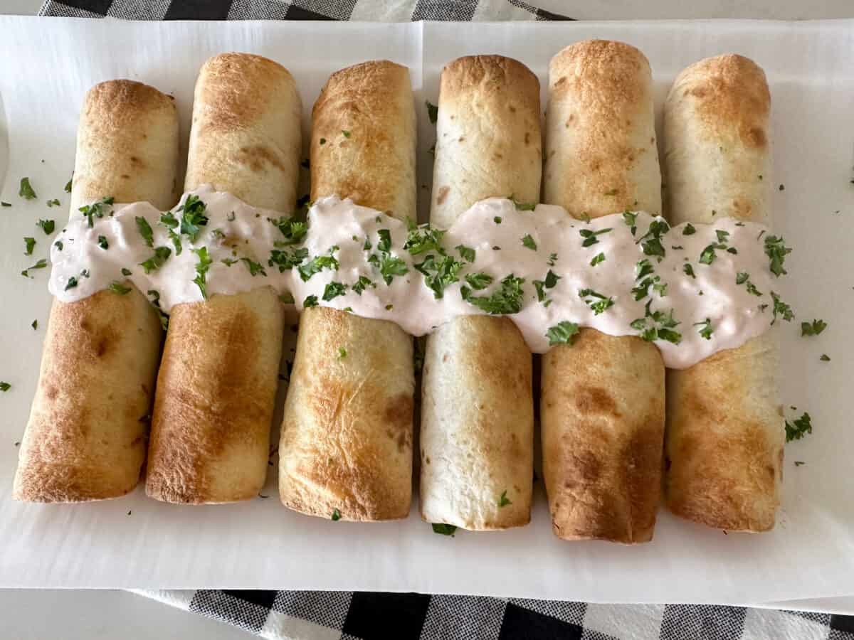 cooked chicken taquitos on serving plate