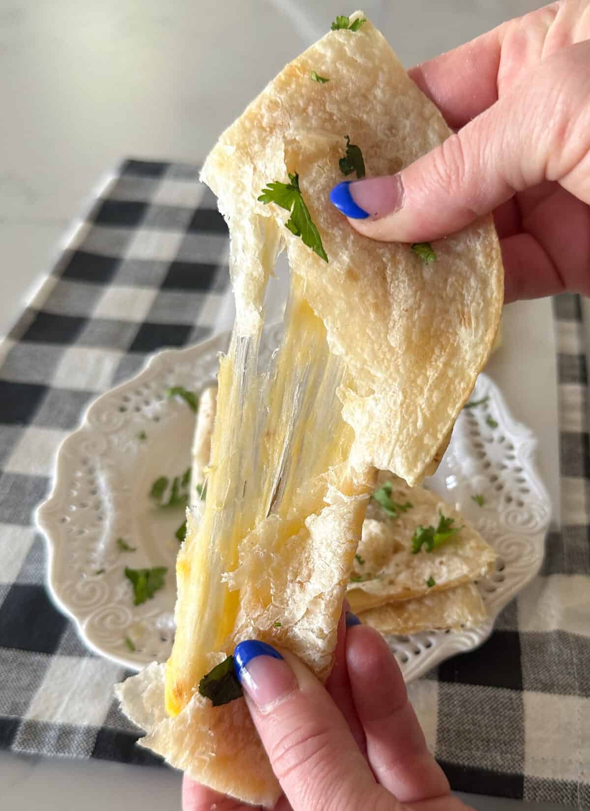 pulling quesadilla to show cheese pull
