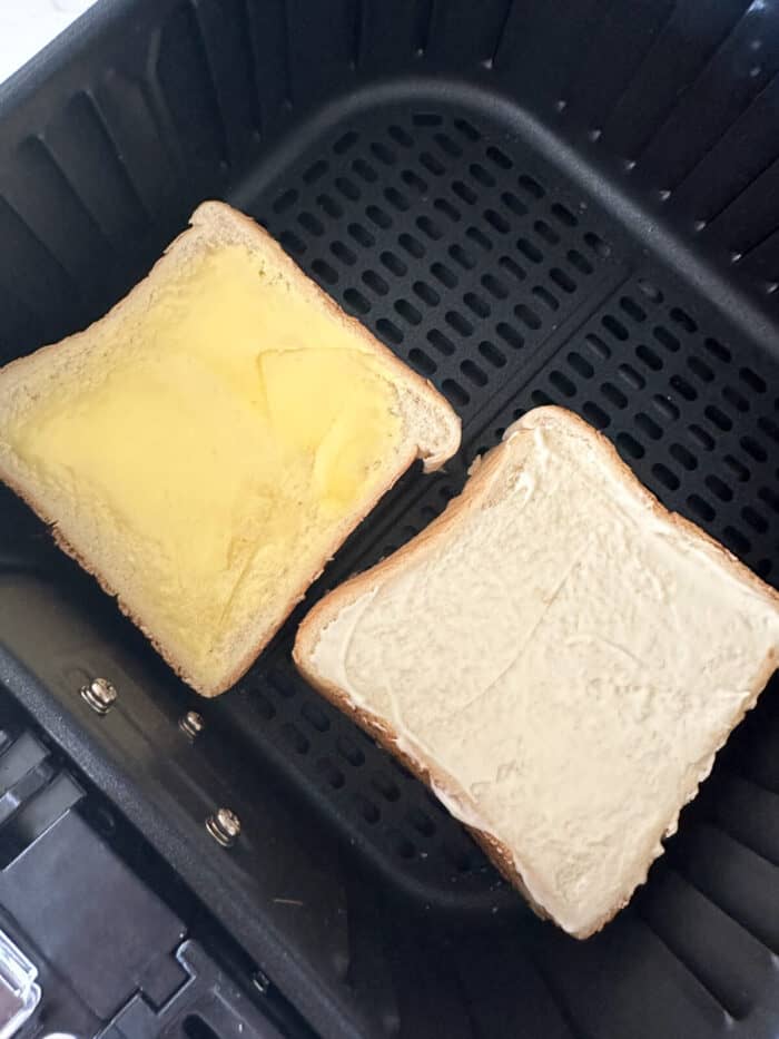 grilled cheese sandwiches placed into air fryer ready to cook