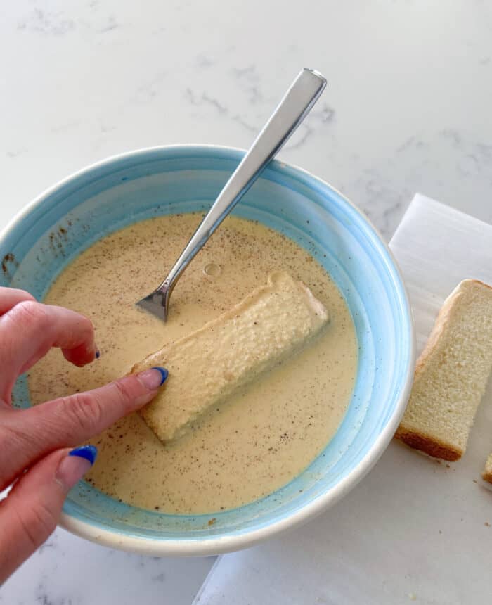 dipping bread into egg mixture for french toast