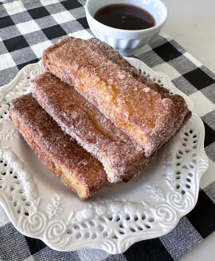 air fryer french toast sticks stacked on plate