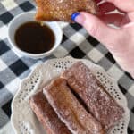 dipping air fryer french toast stick in syrup