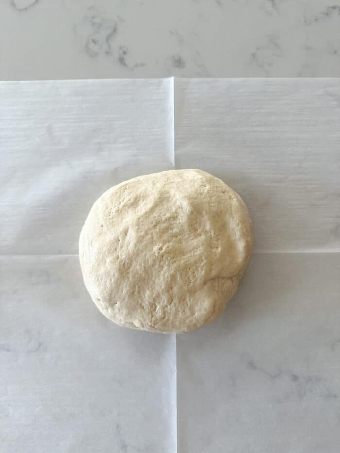 pizza dough on parchment paper