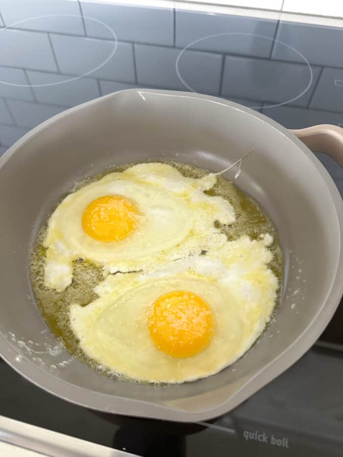 fried eggs cooking in skillet