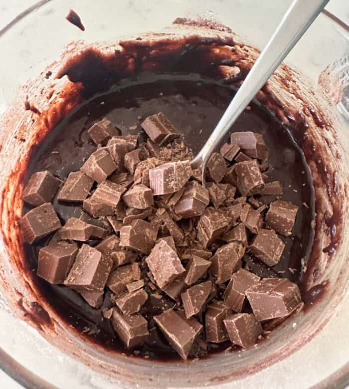 chocolate chunks added to brownie batter in mixing bowl