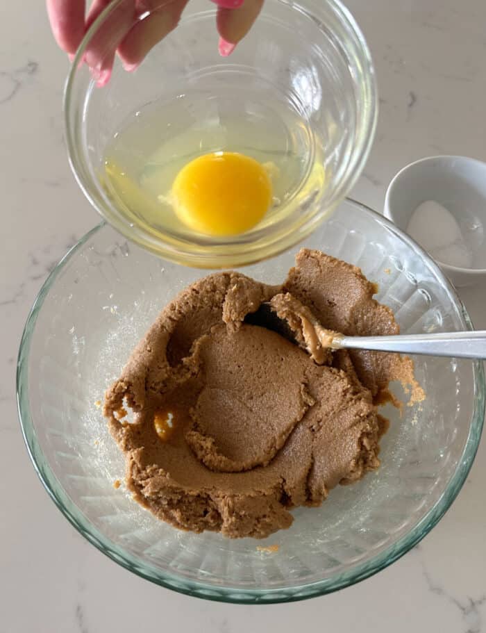 adding egg to peanut butter cookie dough