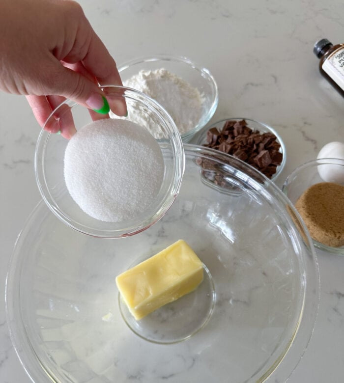 adding sugar to butter in mixing bowl