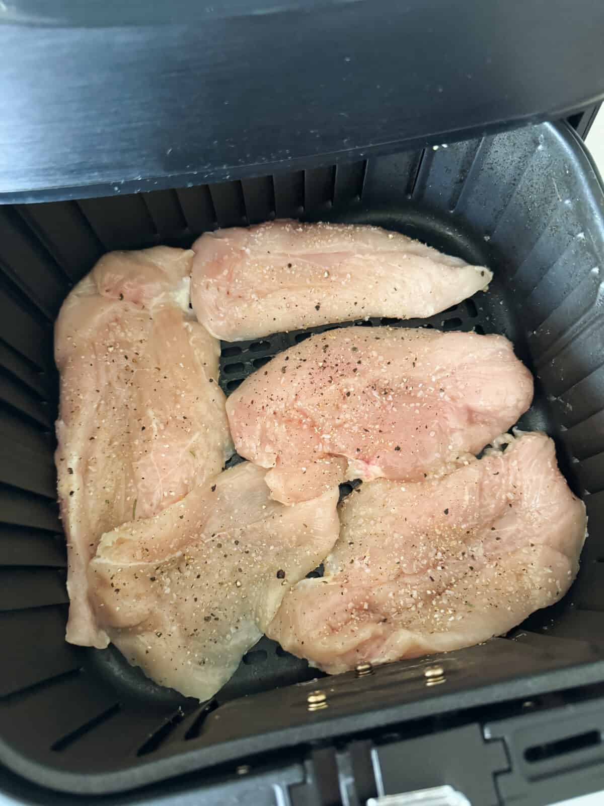 raw chicken placed in air fryer basket