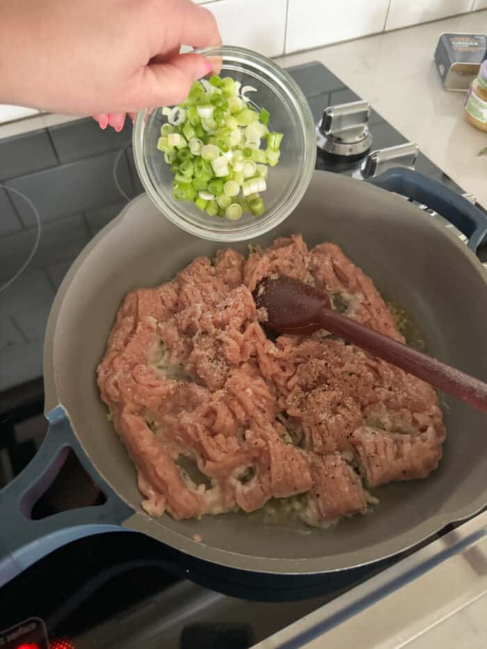 adding onion to ground chicken in skillet