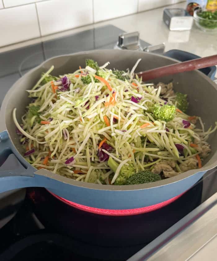 slaw added to cooked chicken in skillet