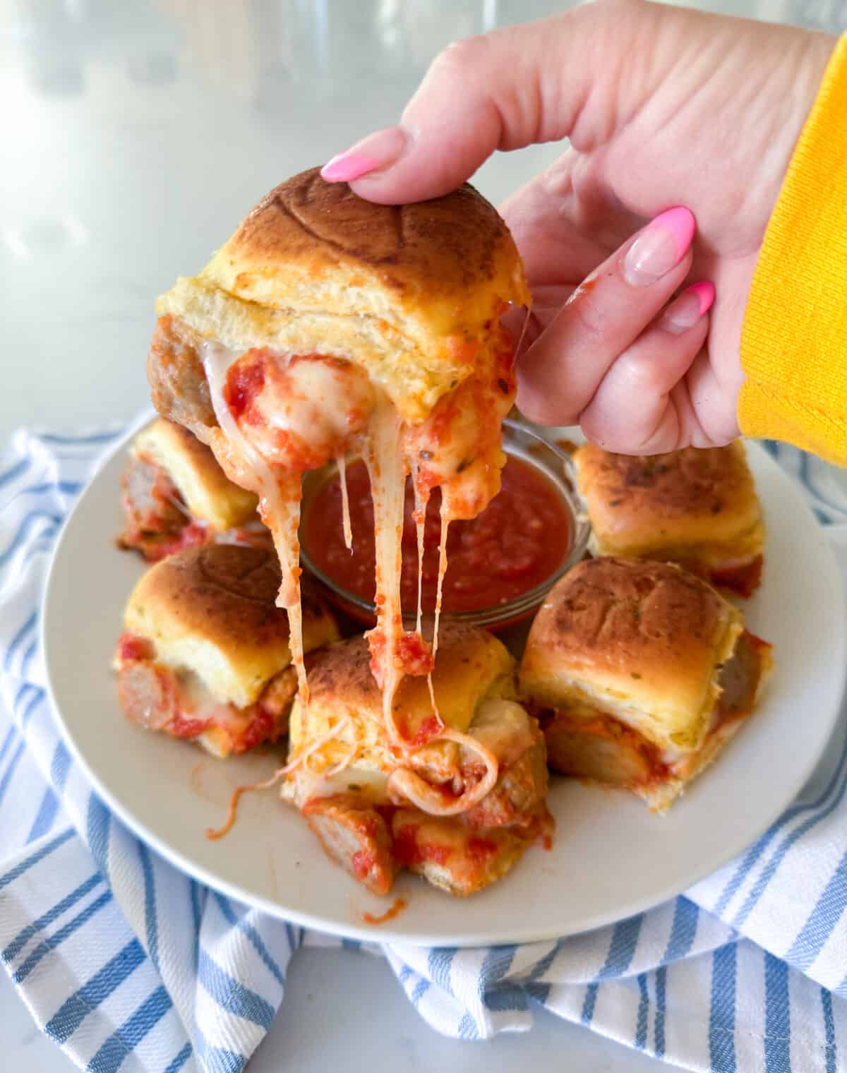 holding meatball slider with oozing cheese