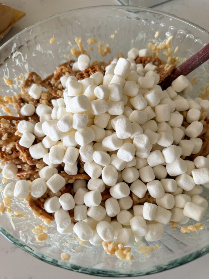 more marshmallows added to mixing bowl of krispie treats