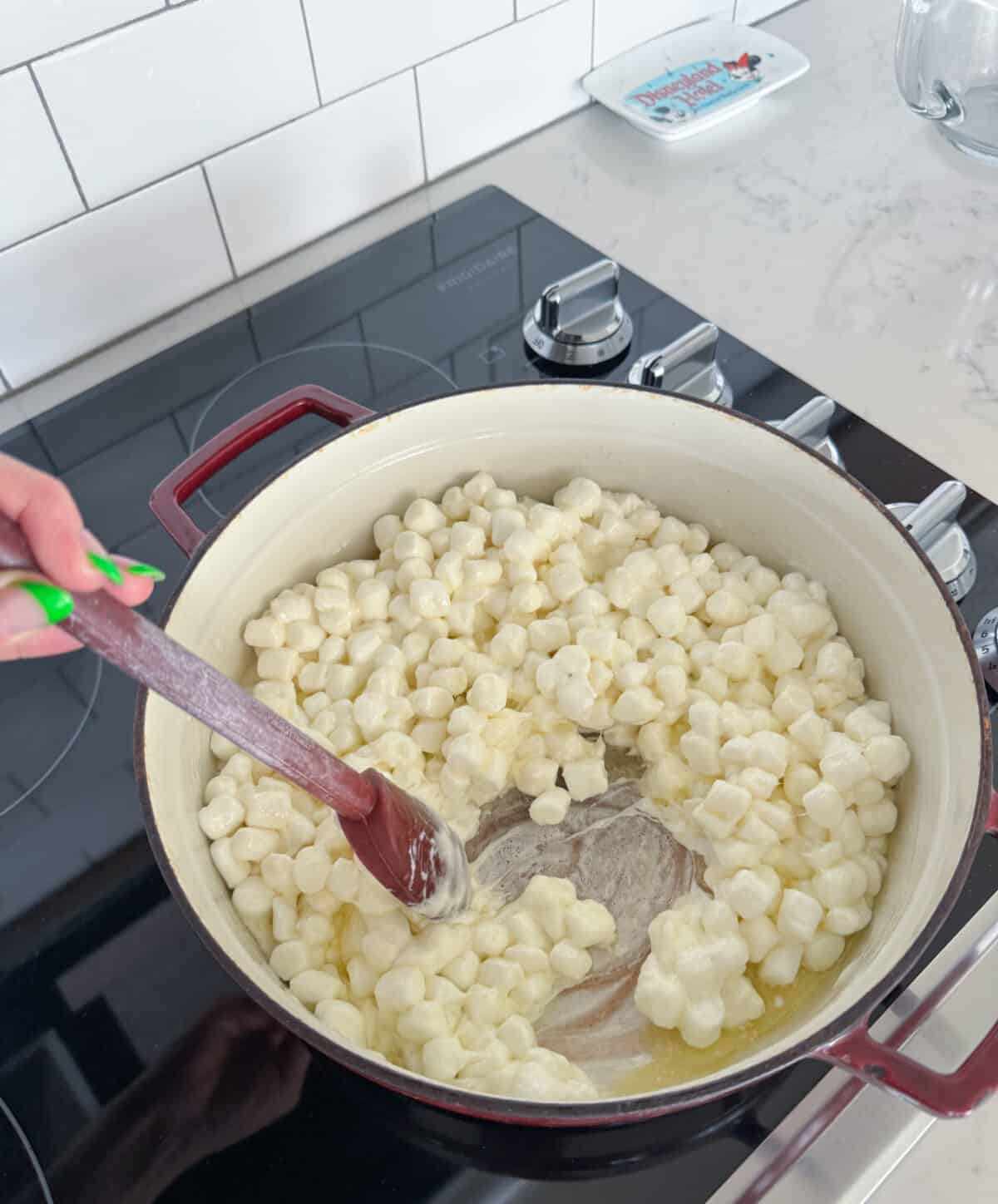 stirring marshmallows and butter in large pot to melt